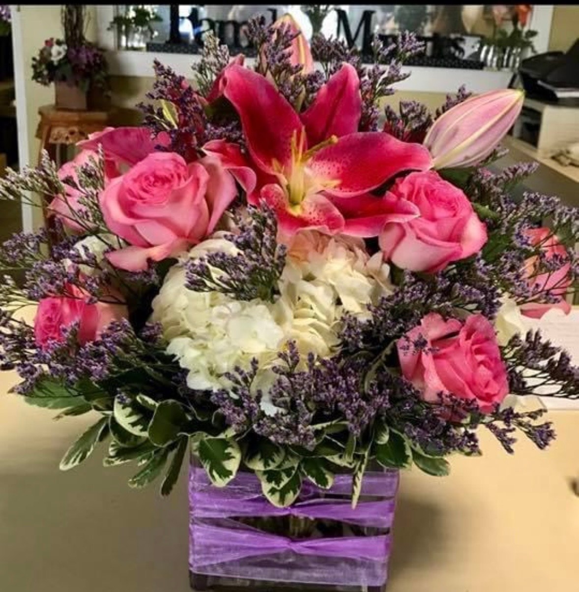 Everyday floral arrangement with pink roses, red lilies, white carnations and purple statice