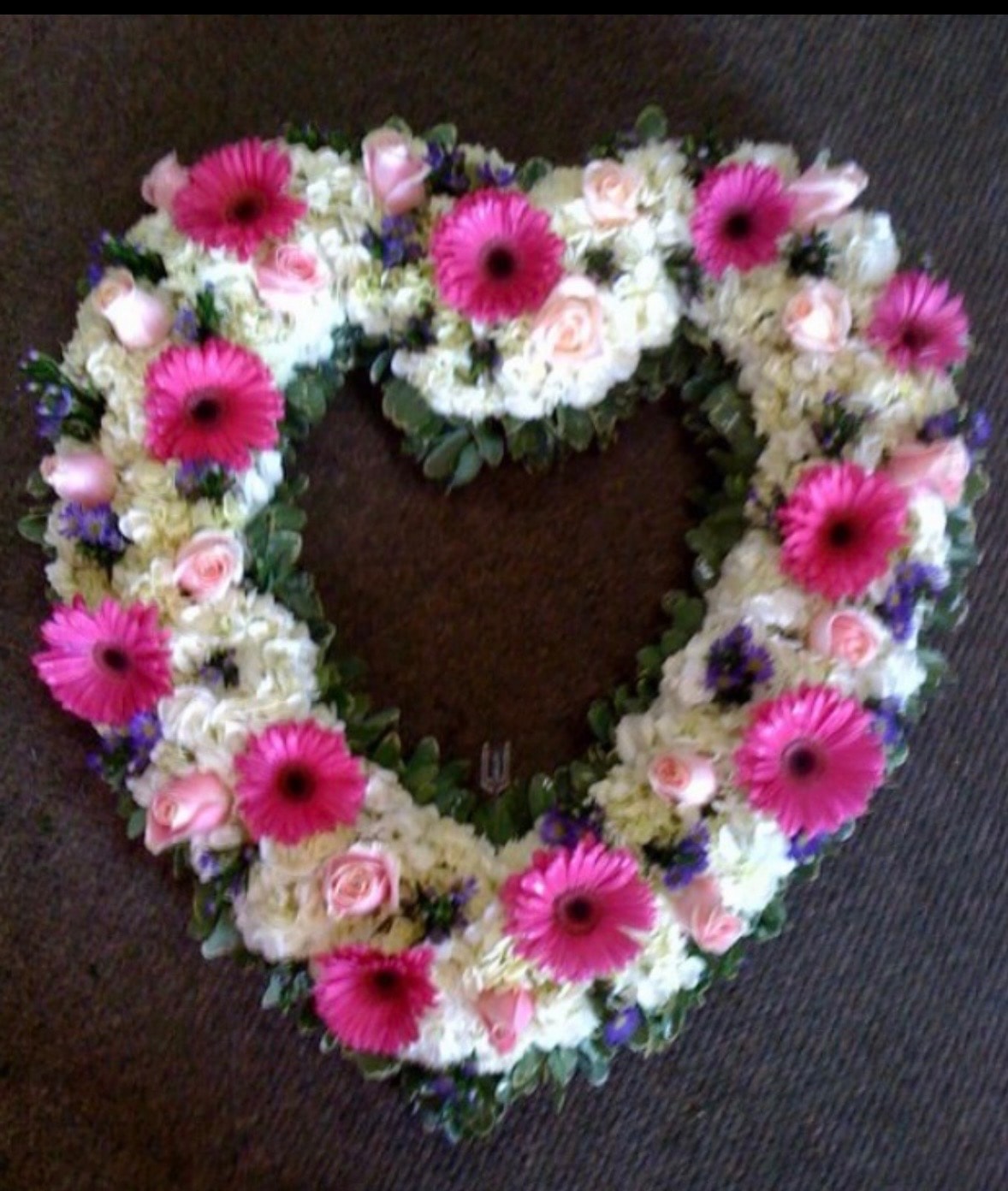 Heart-shaped floral wreath with pink gerberas and roses